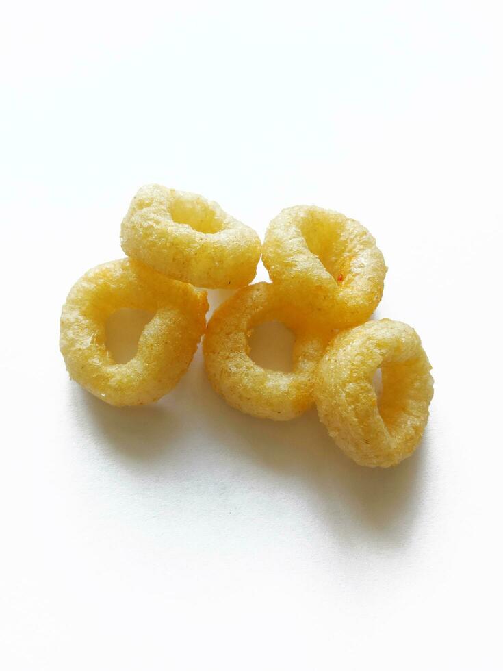 queso crujiente maíz meriendas en un blanco fondo, salado maíz anillos foto