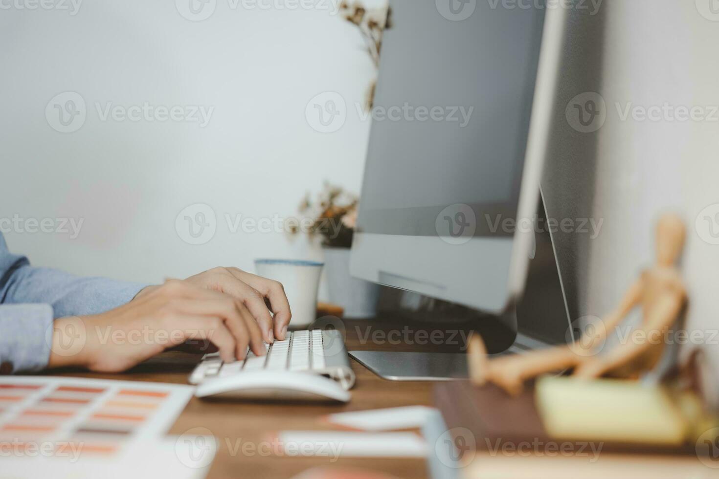 Young creative designer working with keyboard during draft project on a desktop computer. photo