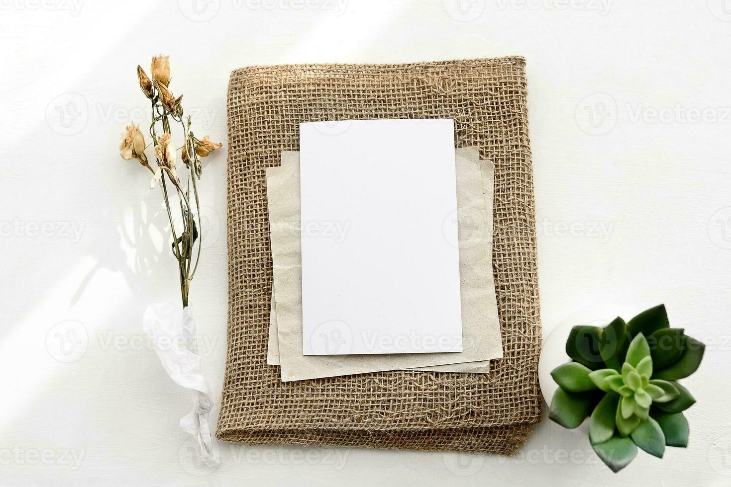 An envelope made of kraft paper and a white blank card on a white table photo