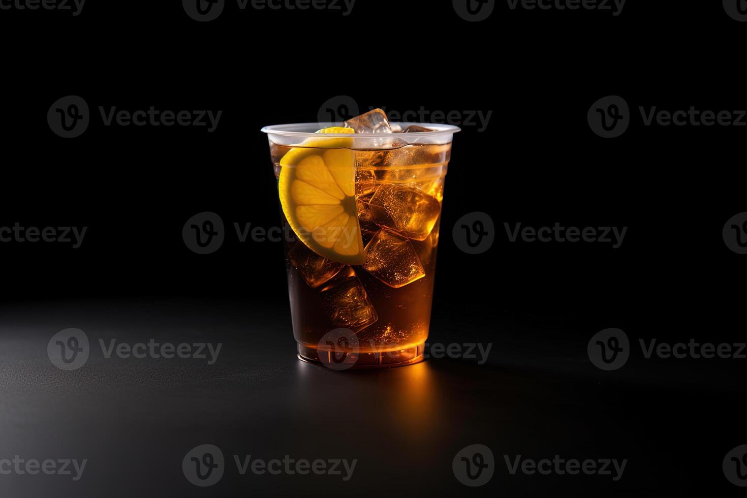 Iced lemon tea on plastic takeaway glass isolated on dark background. photo