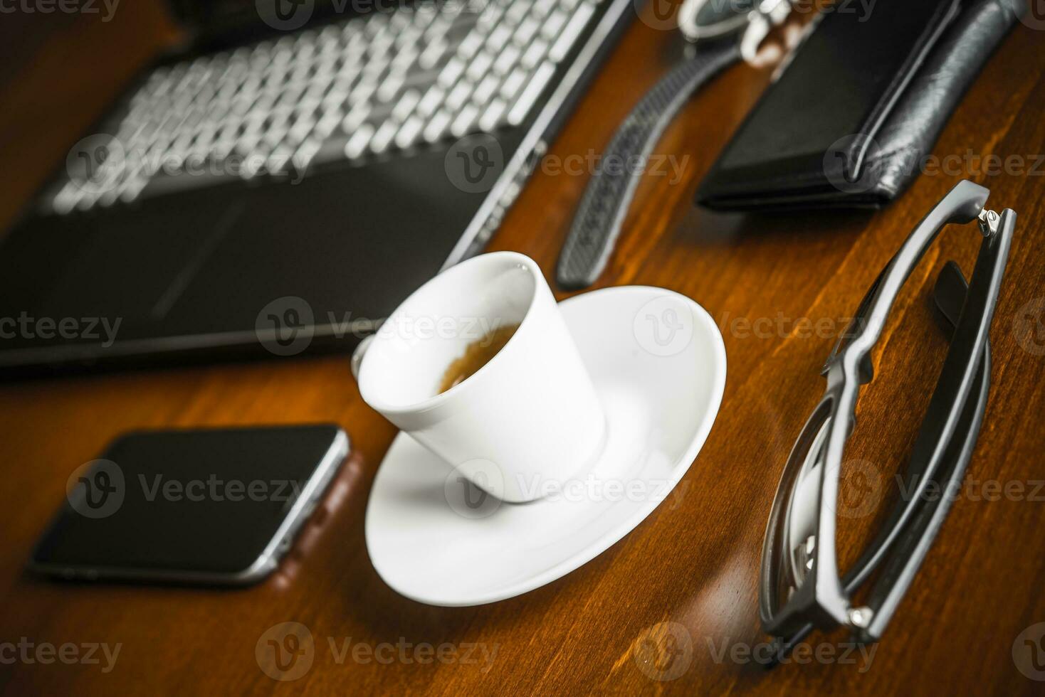 Laptop computer, coffe, watch, glasses and wallet on wooden desk photo