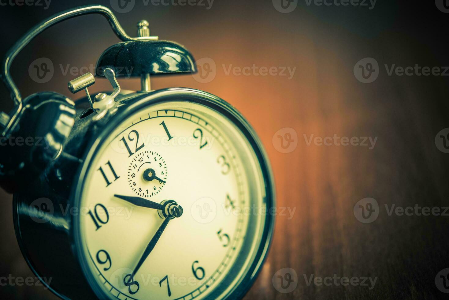 Retro alarm clock on wooden table. Time concept. photo