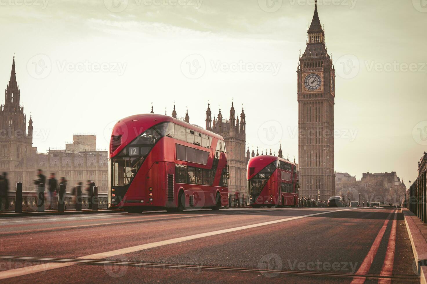 Red London Bus on the Westminster Bridge and Big Ben Tower in the background. photo