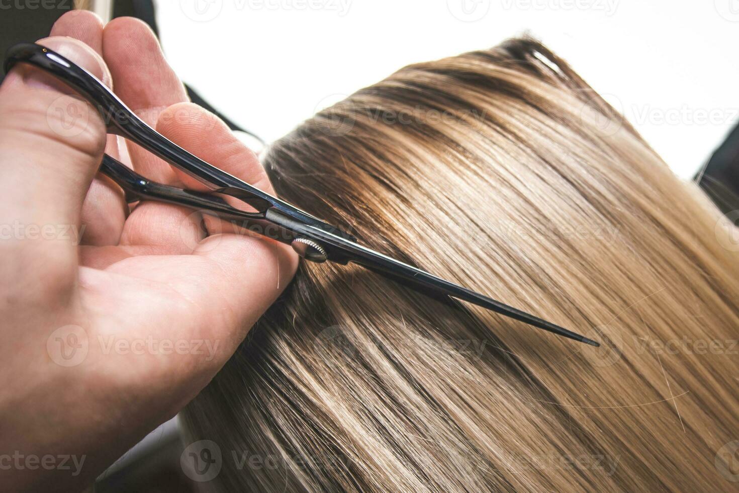 Hairdresser cut hair of a woman. Close-up. photo