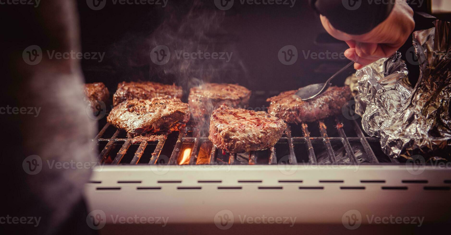 Cocinando filetes en parrilla con fuego. barbacoa tema. foto