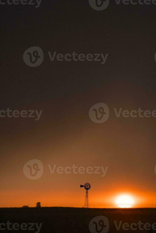 Pampas windmill landscape at sunsetin storm, La Pampa Province,  Argentina photo