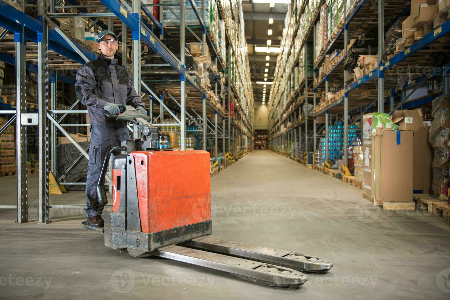 Caucasian Worker in uniform with pallet jack photo