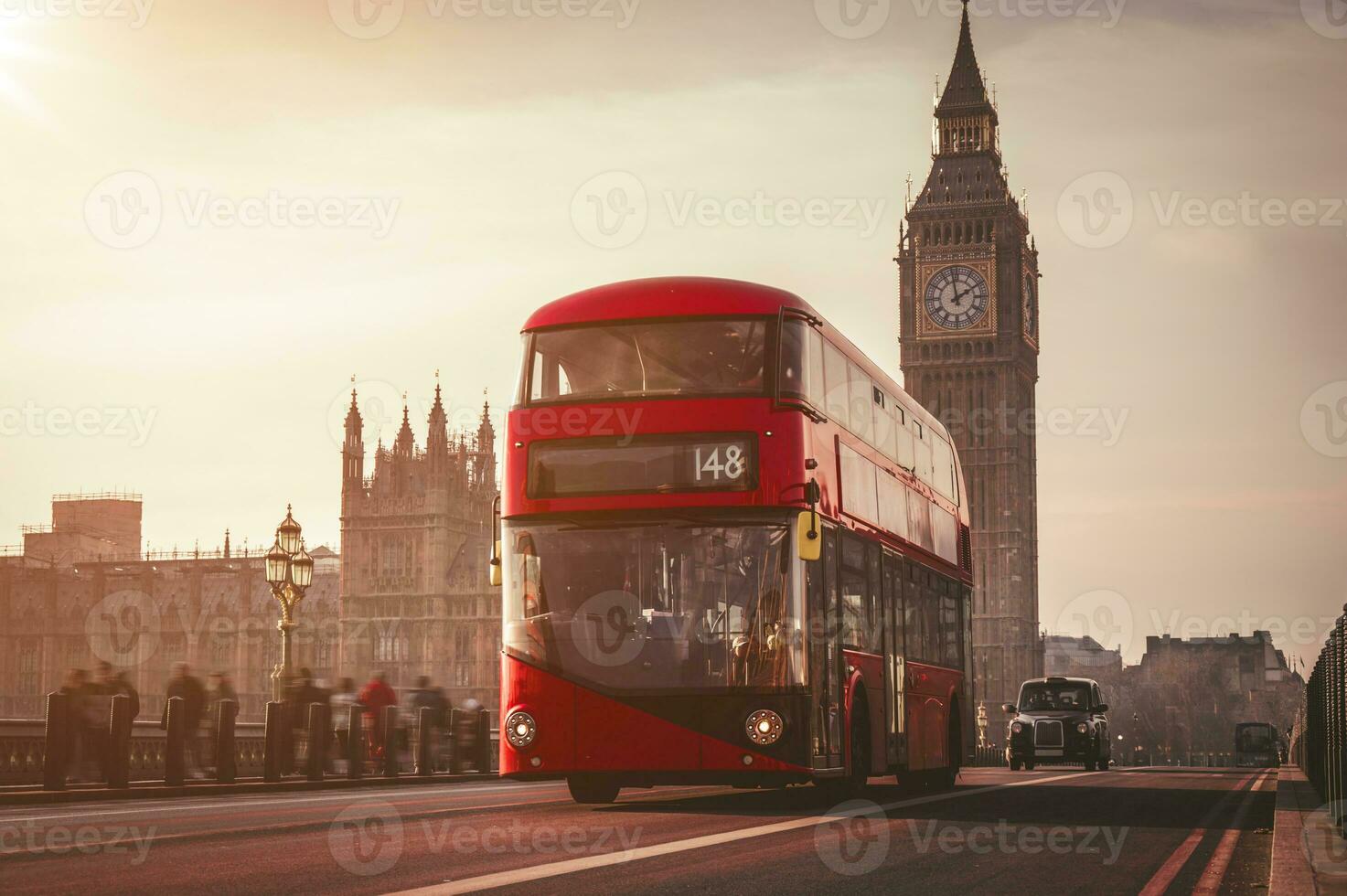 Red London Bus on the Westminster Bridge and Big Ben Tower in the background. photo