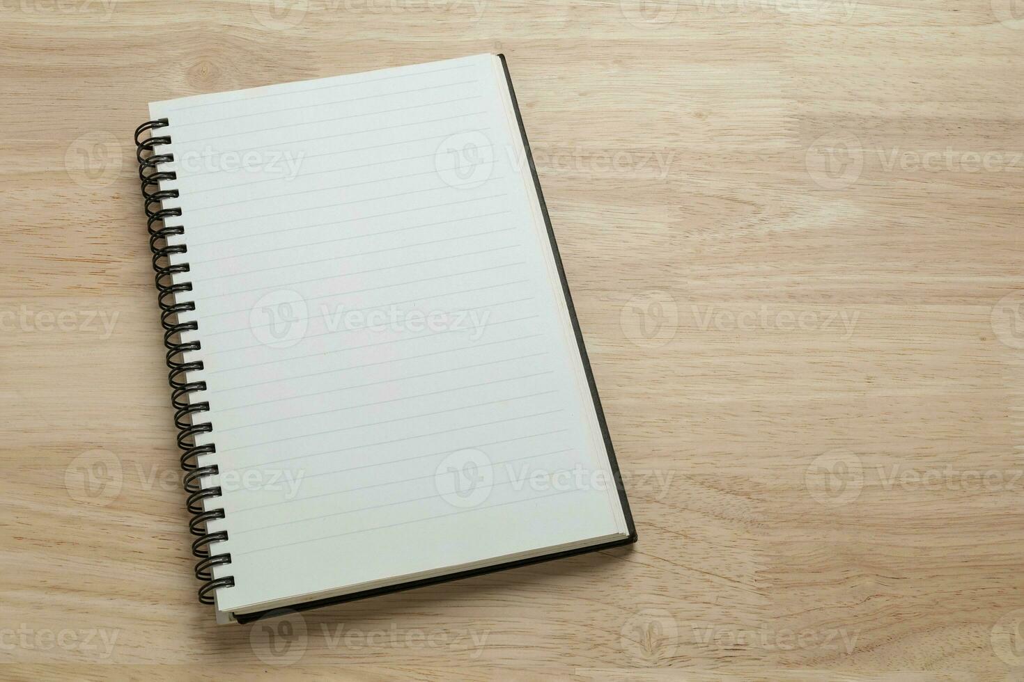 blank spiral notebook on wooden table for mockup blank template photo