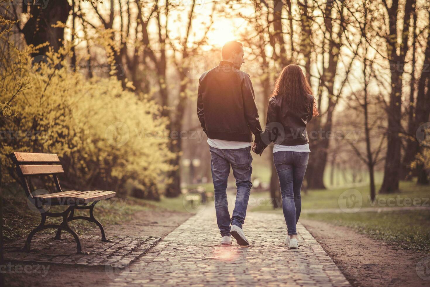 Couple holding hands walking towards sunset. Love theme. Relationship. photo