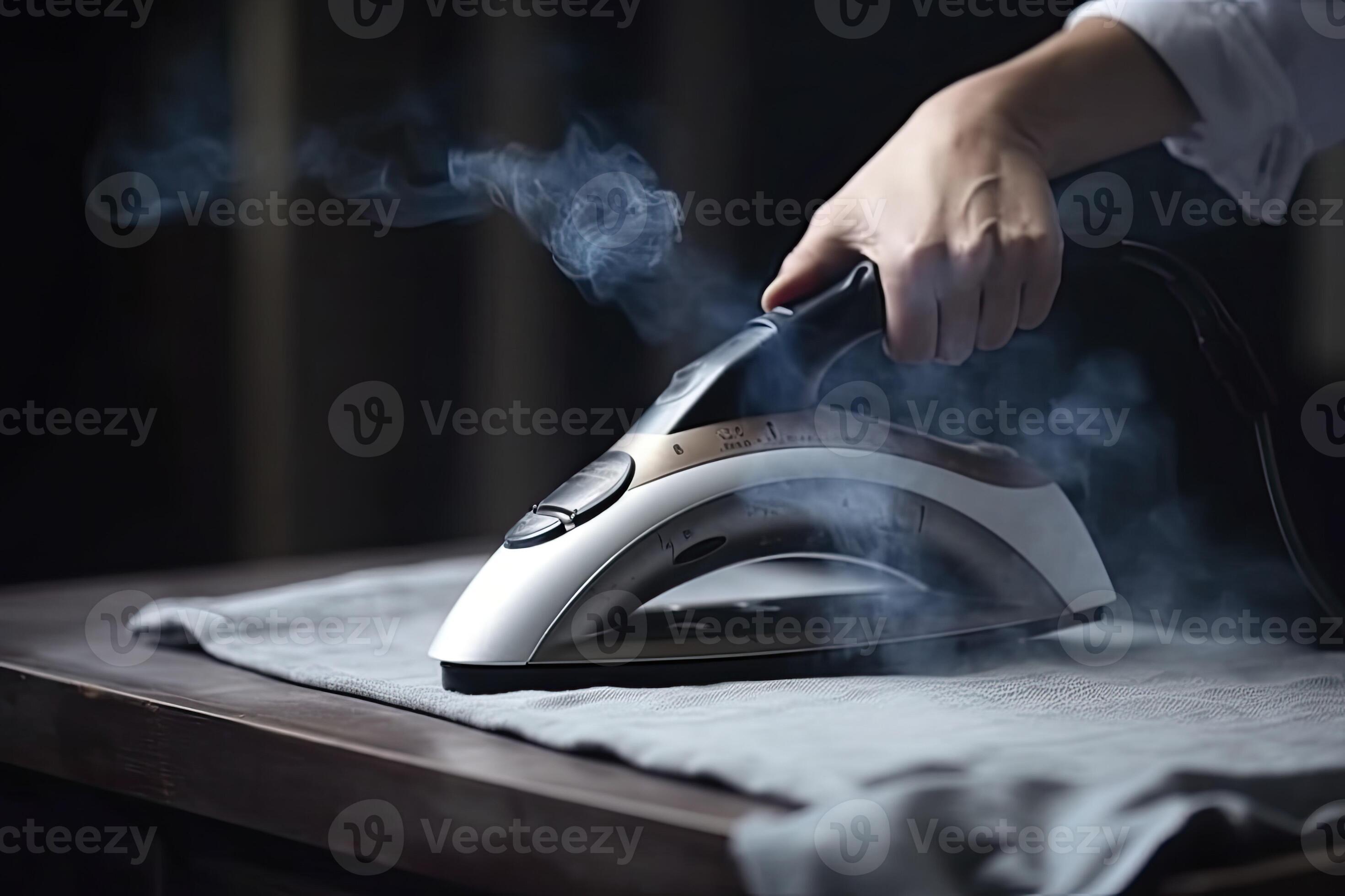 Hands ironing a shirt collar on ironing board, view from the side