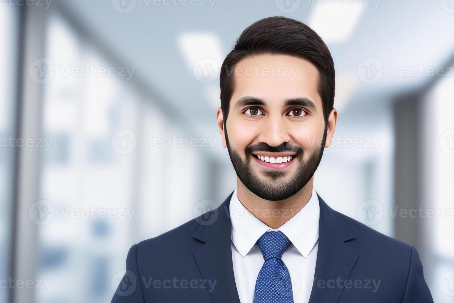 Young smart businessman, standing in blur background of office. photo
