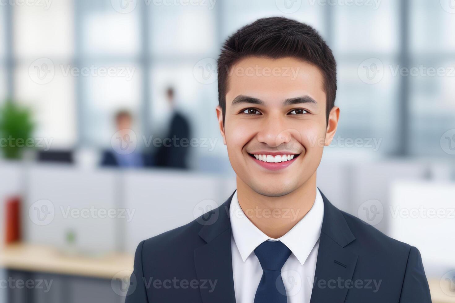 Young smart businessman, standing in blur background of office. photo