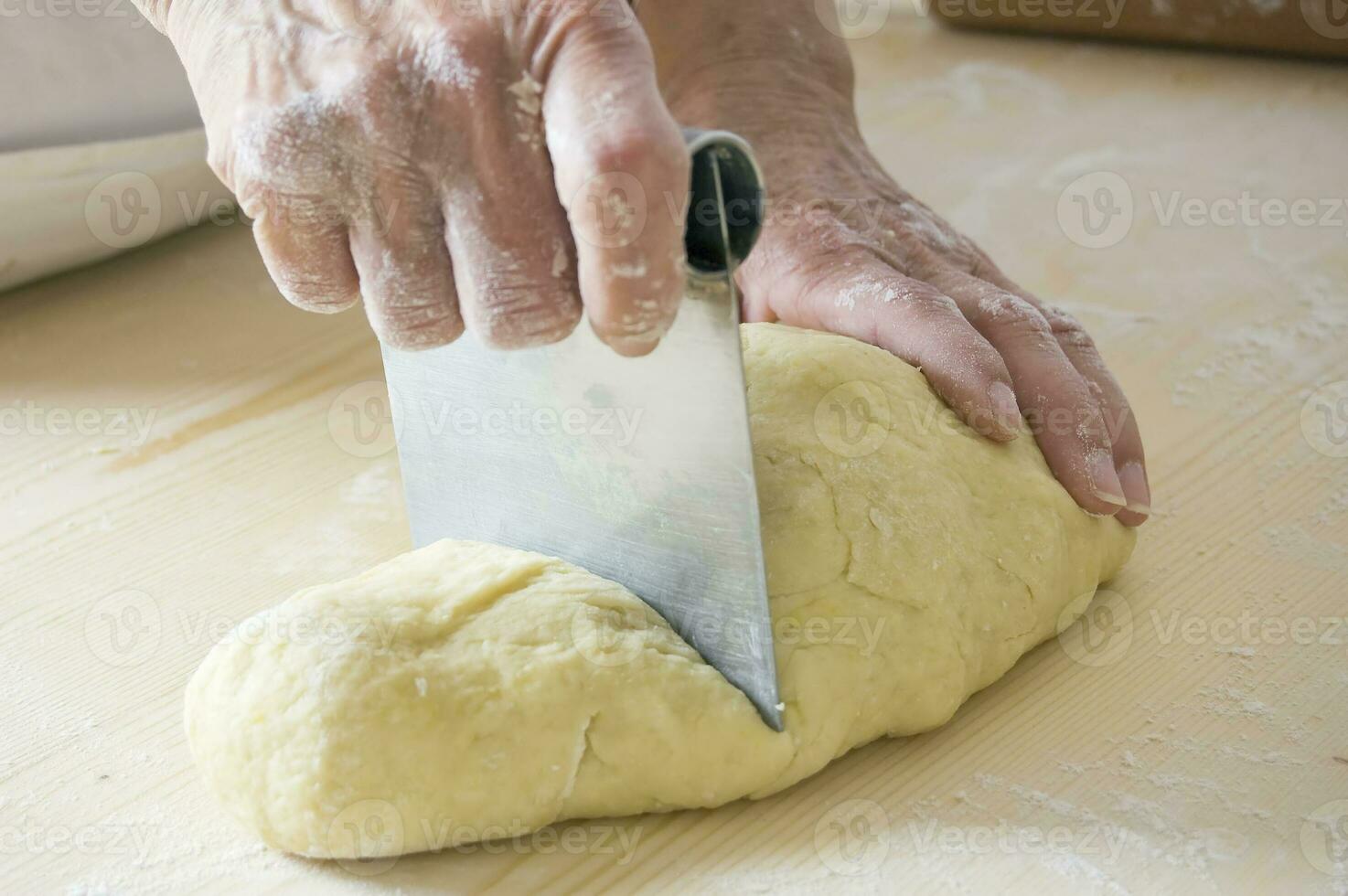 Hands Splitting Dough with Device photo