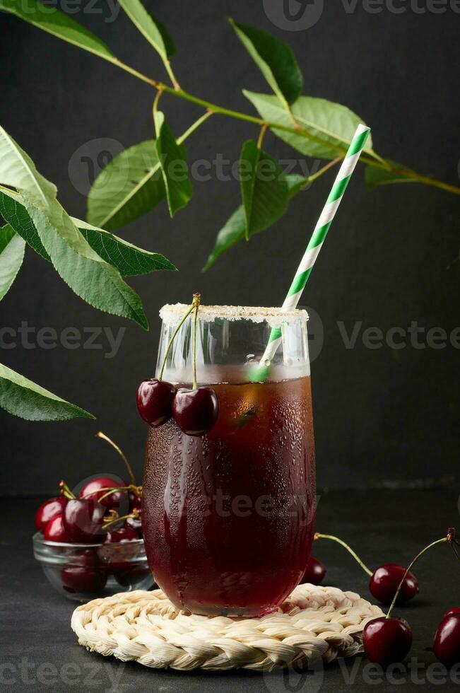Cherry juice in a glass on a black background photo