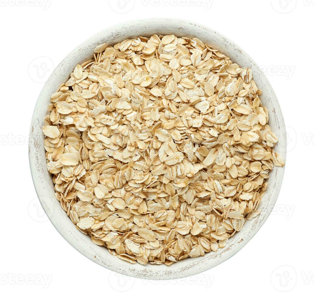 Raw oatmeal in a white wooden bowl on a white background photo