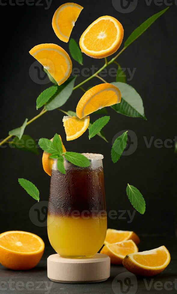 Iced coffee with orange juice in a transparent glass, refreshing bumble coffee on the table photo