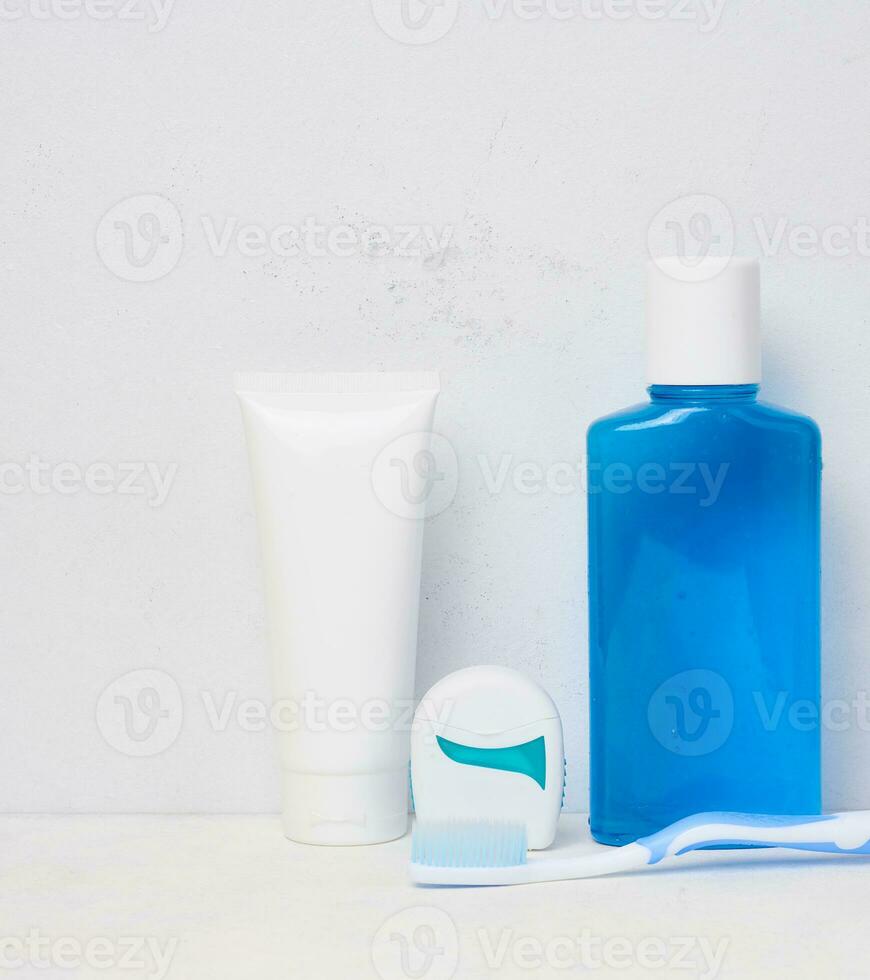 refrescante enjuague bucal en un transparente el plastico botella y dental seda floja en un blanco antecedentes foto