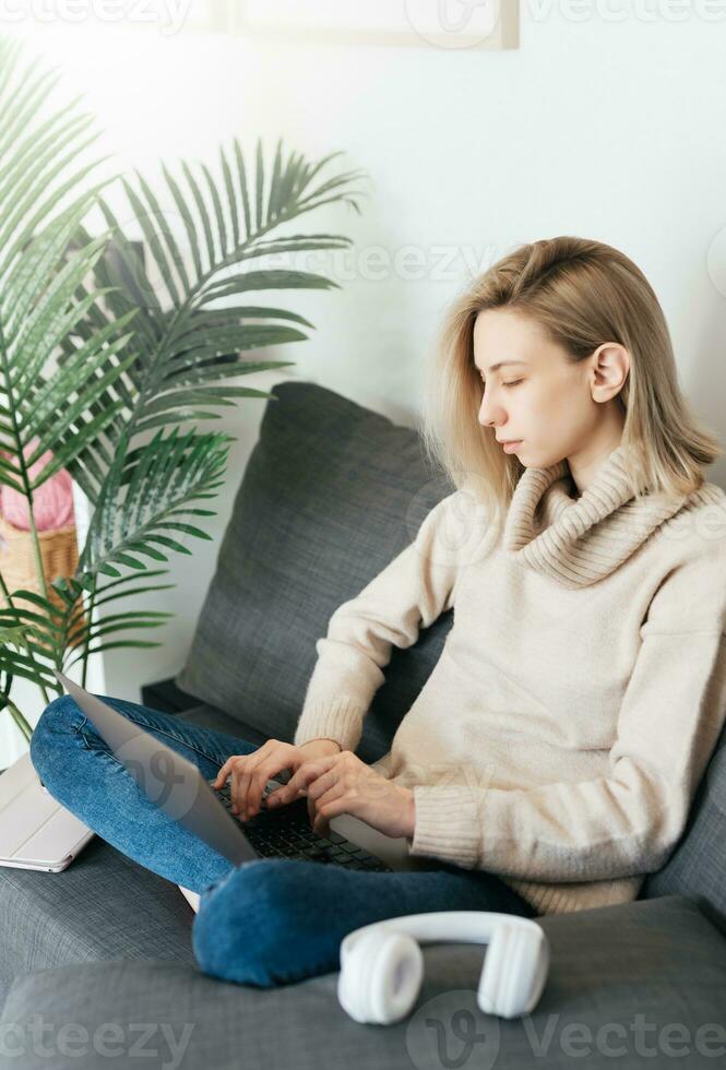 Young woman working on laptop in  home photo