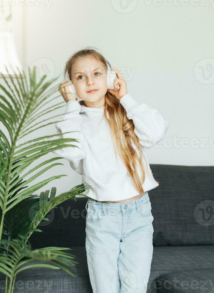 Cute little girl listening to music in headphones photo