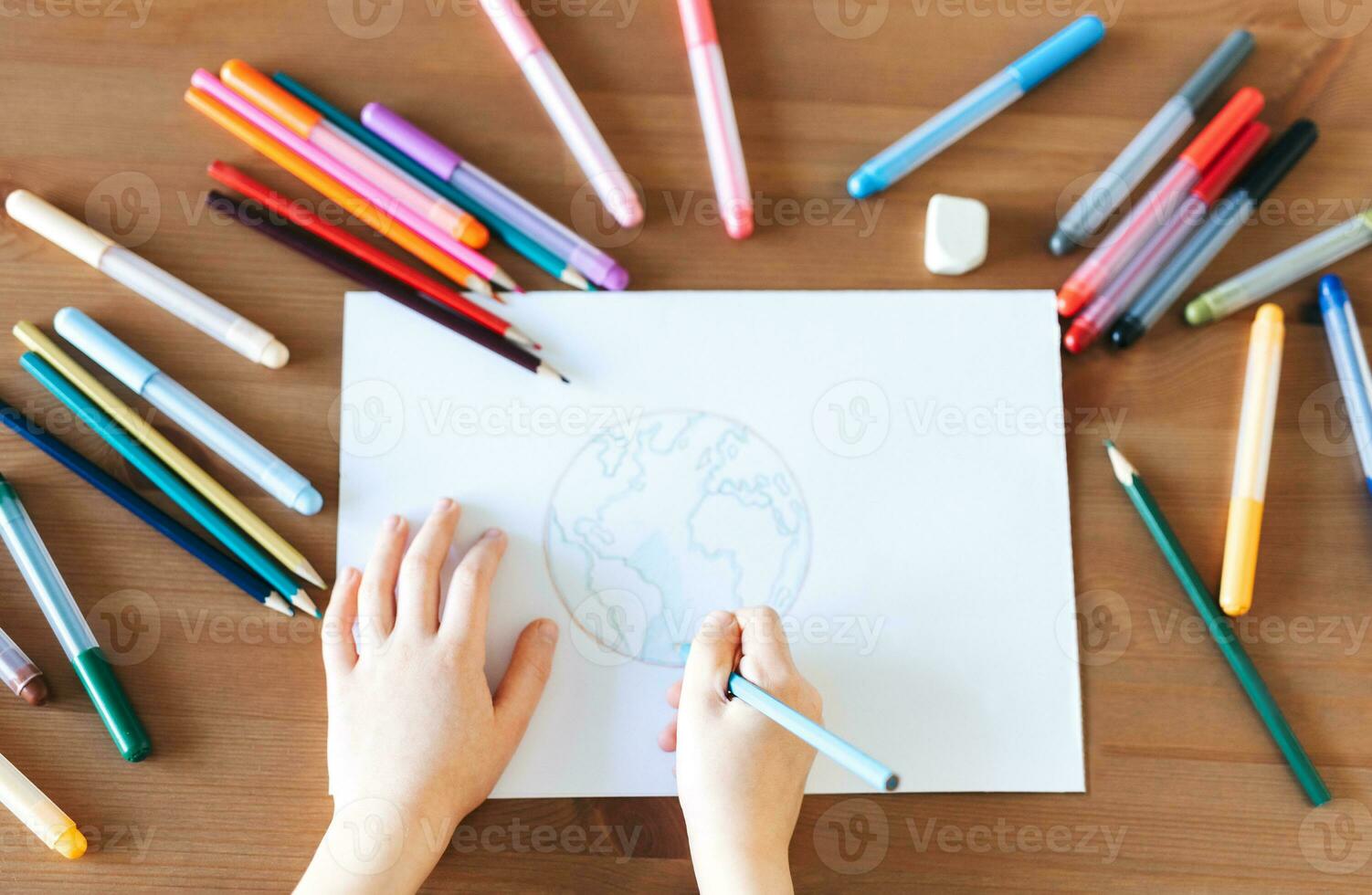 Child girl drawing with colorful pencils photo