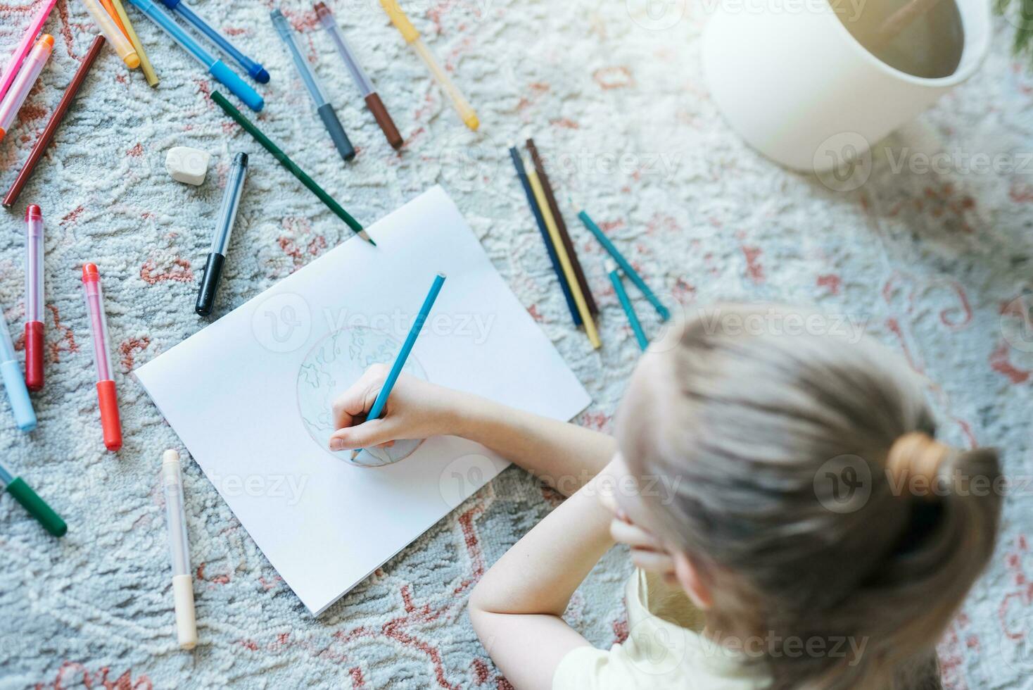 Child girl drawing with colorful pencils photo