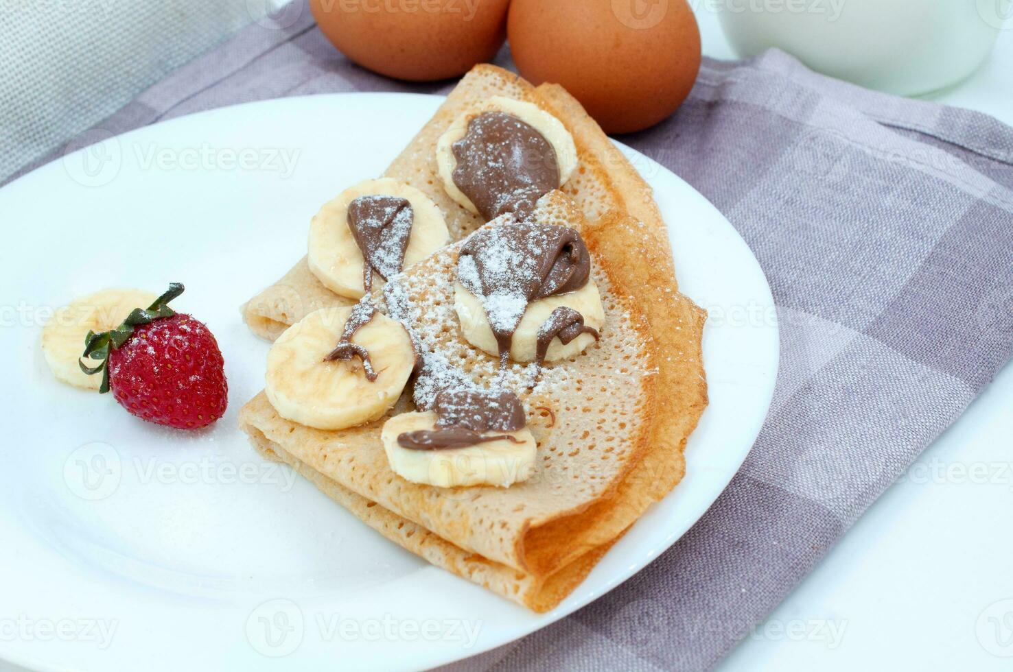 Pancakes with strawberries and ingredients for cooking photo