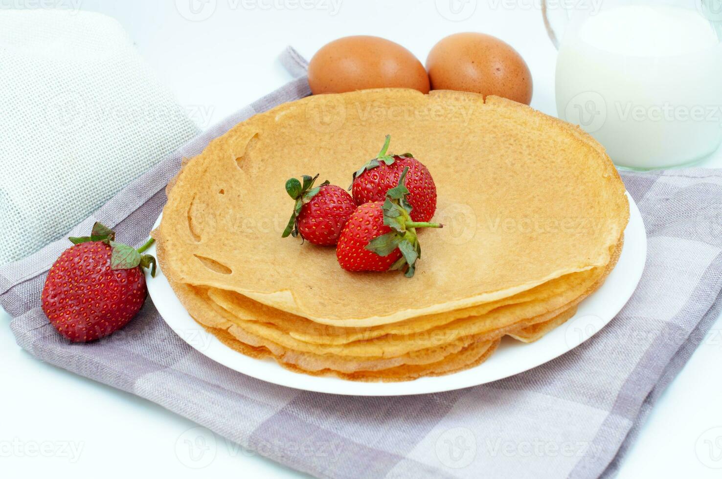 Pancakes with strawberries and ingredients for cooking photo