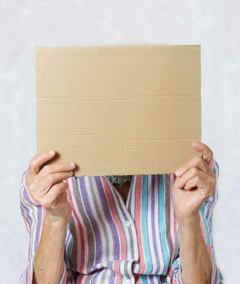 antiguo mujer con un pedazo de caja de cartón papel foto