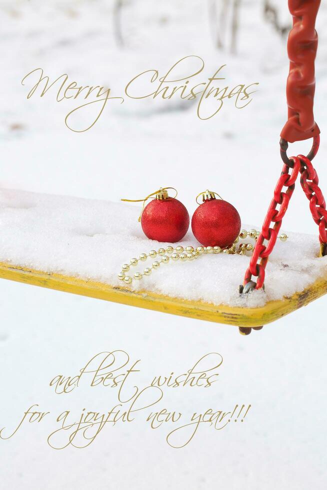 Christmas balls in the snow on a swing seat photo