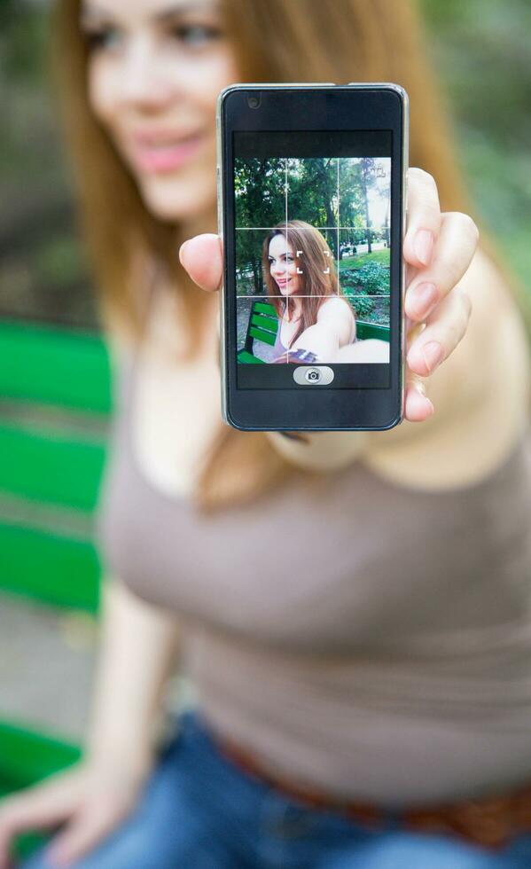 joven atractivo mujer es tomando selfie foto