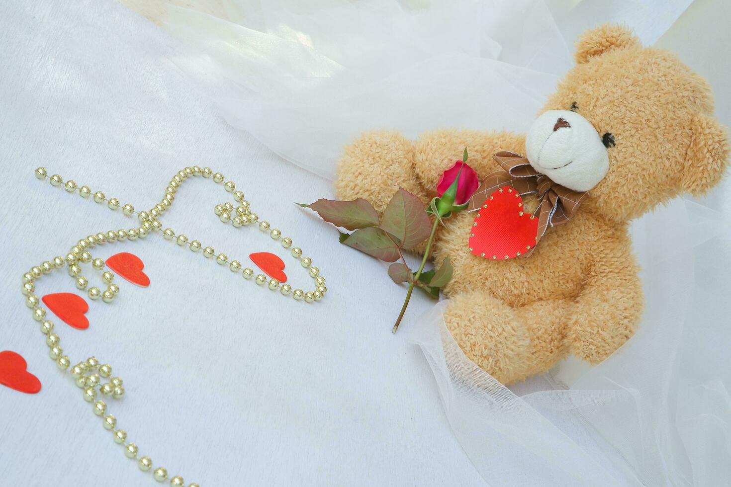 Teddy bear with red heart and red rose photo