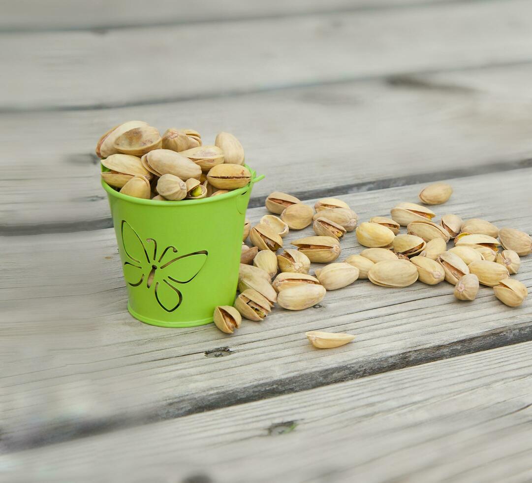 Pistachio nuts on a wooden surface photo