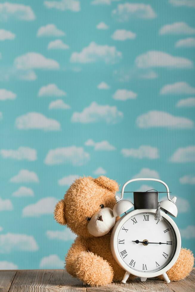 Brown plush teddy bear with academic cap on the top. photo