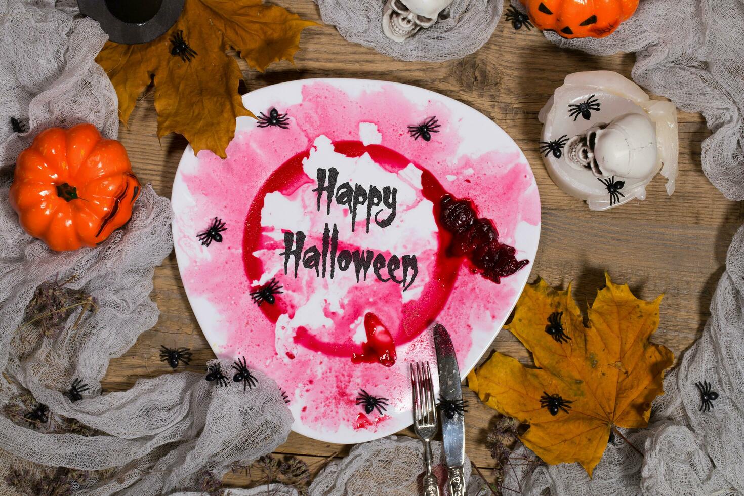 Happy Halloween. Dirty red bloody plate with silver cutlery on Halloween table. , plate photo