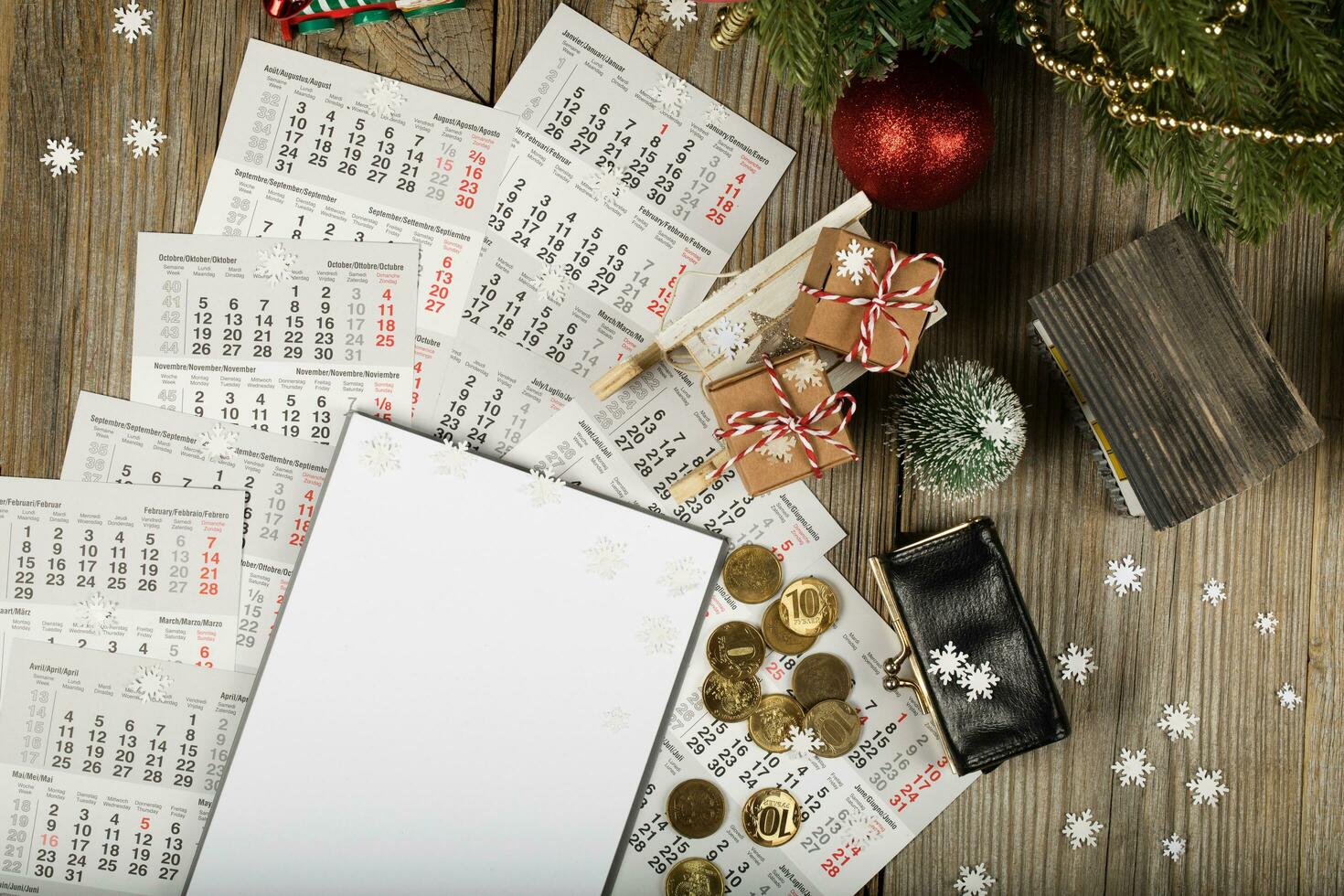 Blank sheet of paper and small purse with coins on the New Year's background. photo