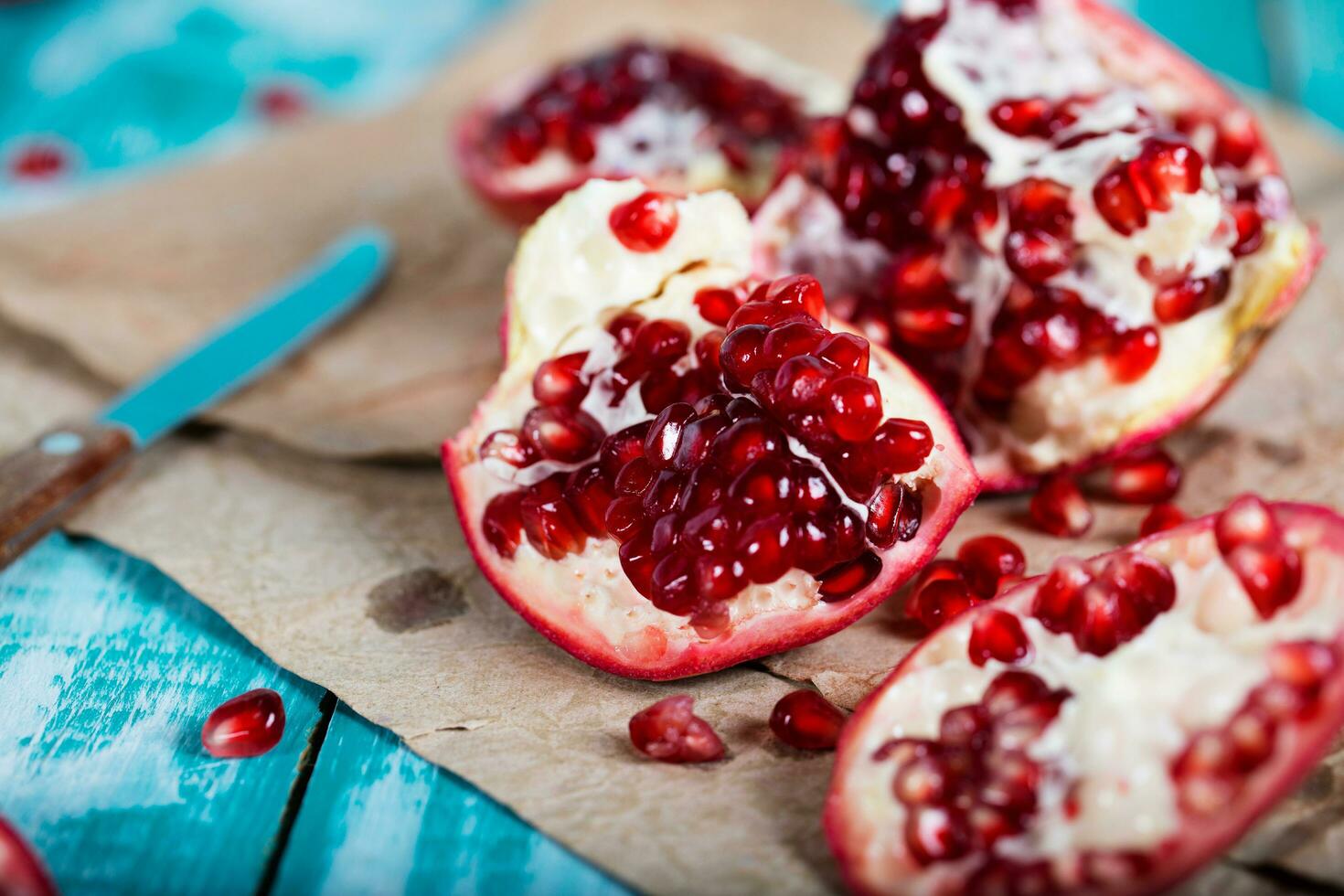 Pomegranate fruit on a cyan wooden surface. photo