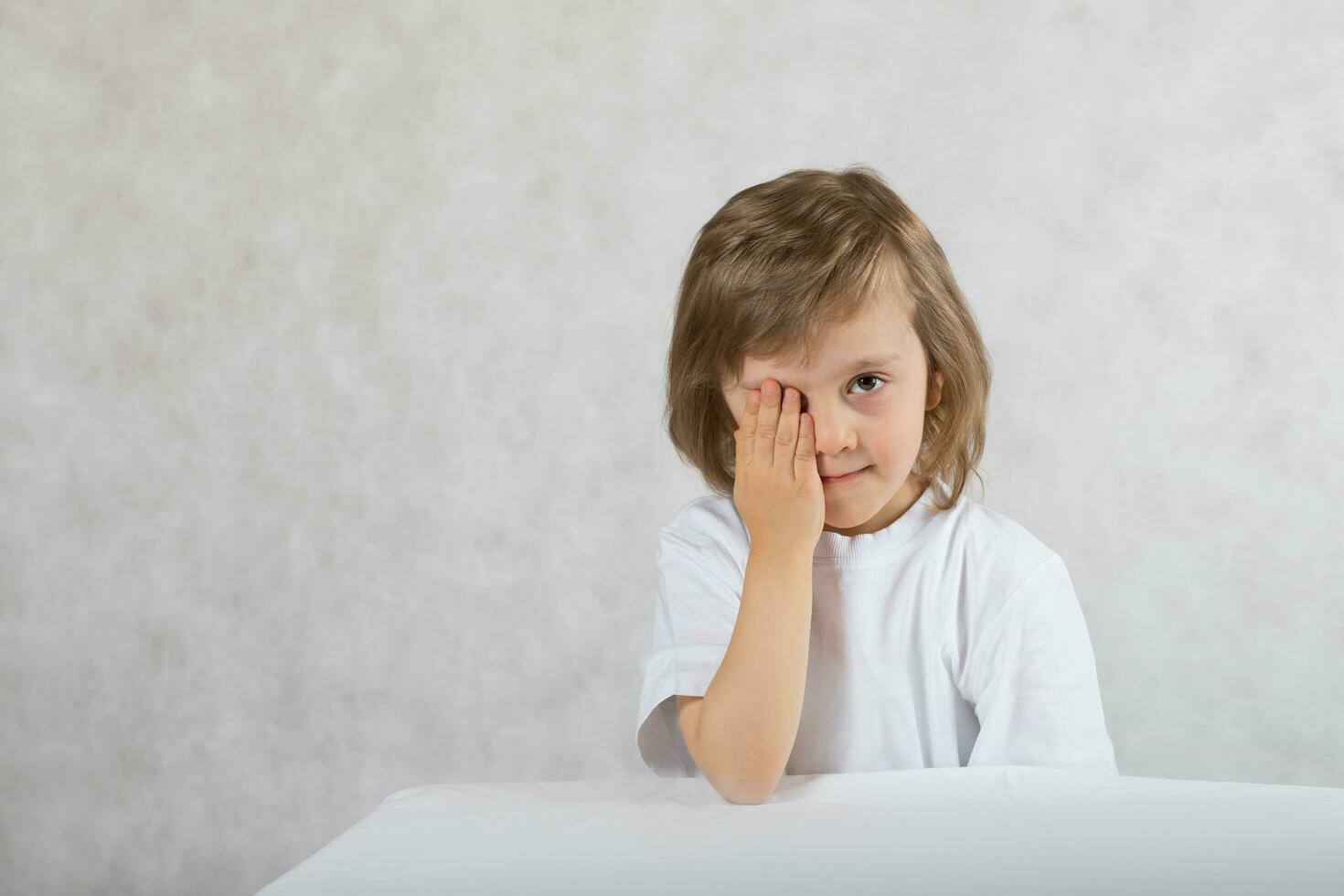 Boy of 5 years old closes one eye. photo