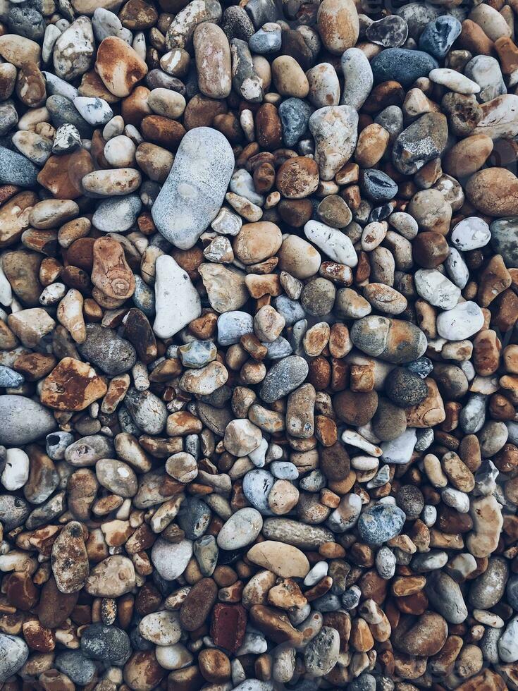 Round stones pebbles scattered as background texture photo