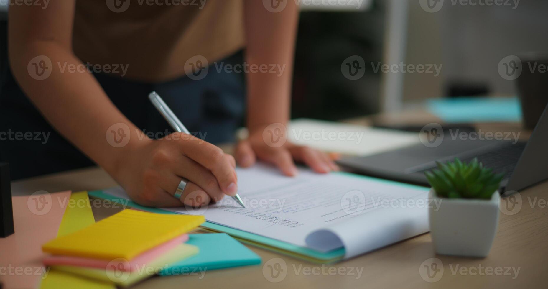 joven asiático mujer escritura en papel mientras en pie en el vivo habitación foto