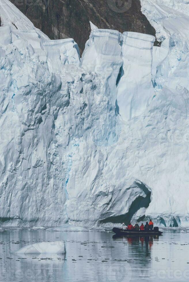 Tourists observing a glacier on the Antarctica, Paradise bay, Antartic Peninsula. photo