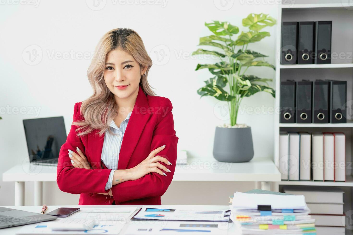 Portrait of a woman business owner showing a happy smiling face as he has successfully invested in her business using tablets and financial budget documents at work. photo