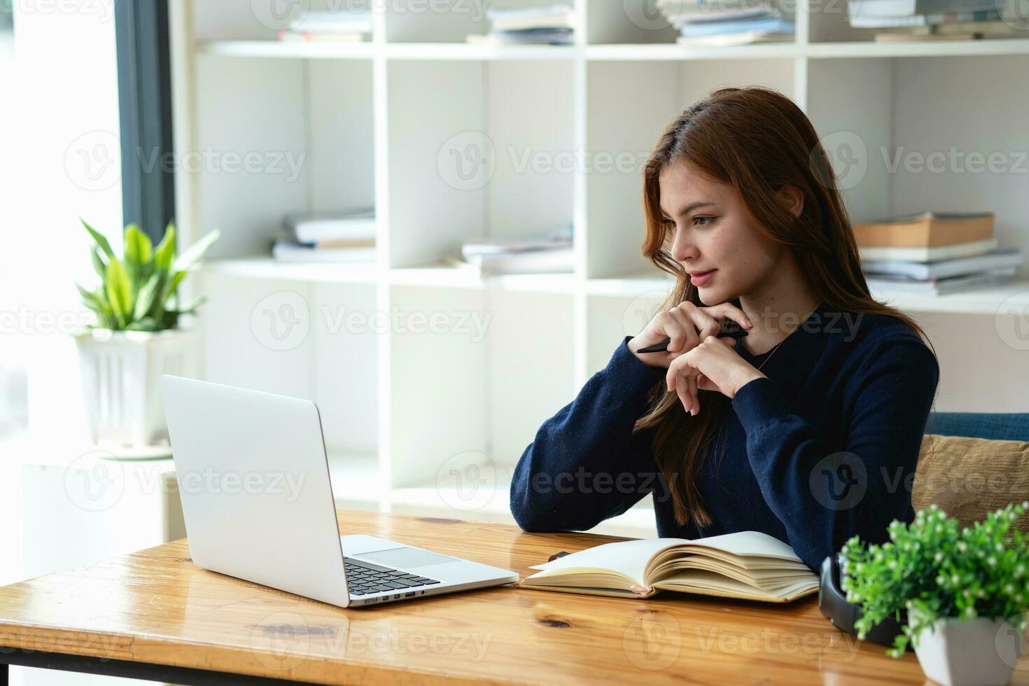 Happy young Latin female college student studying online remotely Distance university webinars Or video call on your laptop and use your computer for a virtual meeting seminar at home or on campus. photo