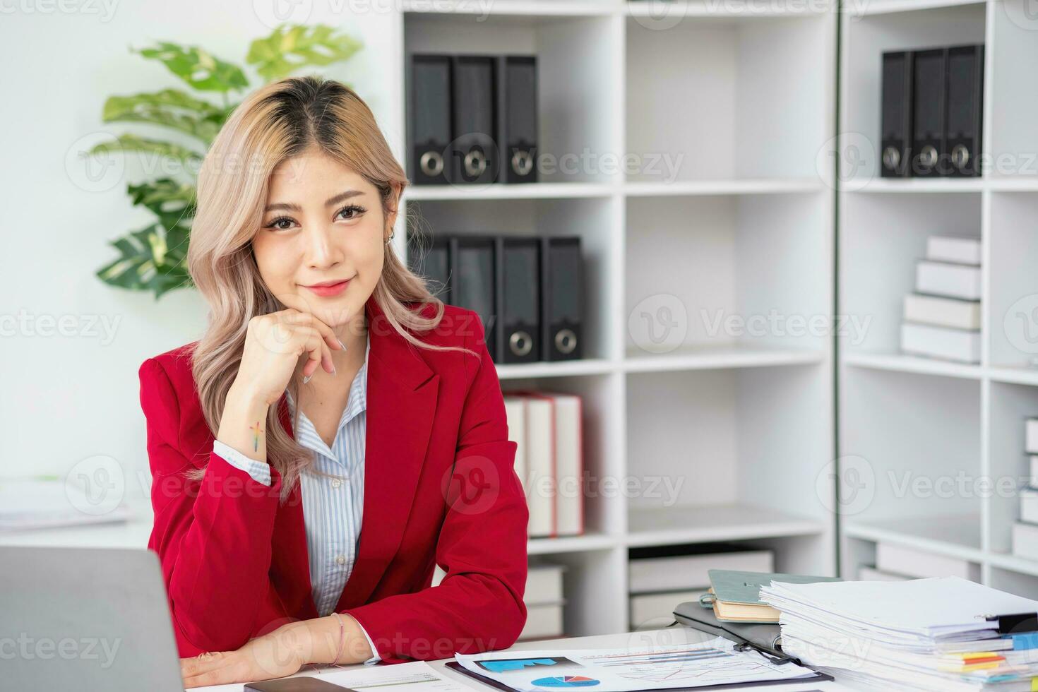 Portrait of a woman business owner showing a happy smiling face as he has successfully invested in her business using tablets and financial budget documents at work. photo