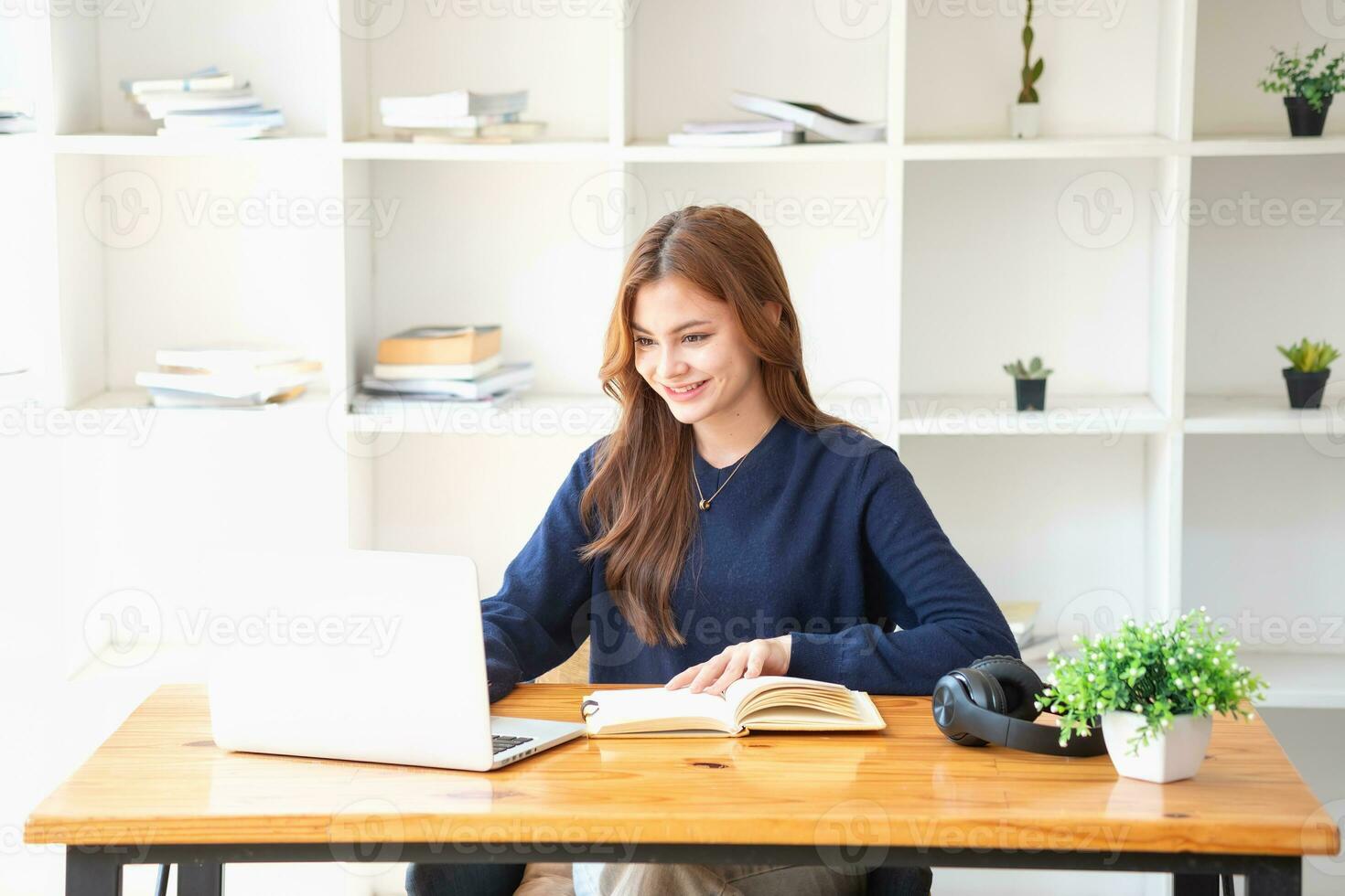 Happy young Latin female college student studying online remotely Distance university webinars Or video call on your laptop and use your computer for a virtual meeting seminar at home or on campus. photo
