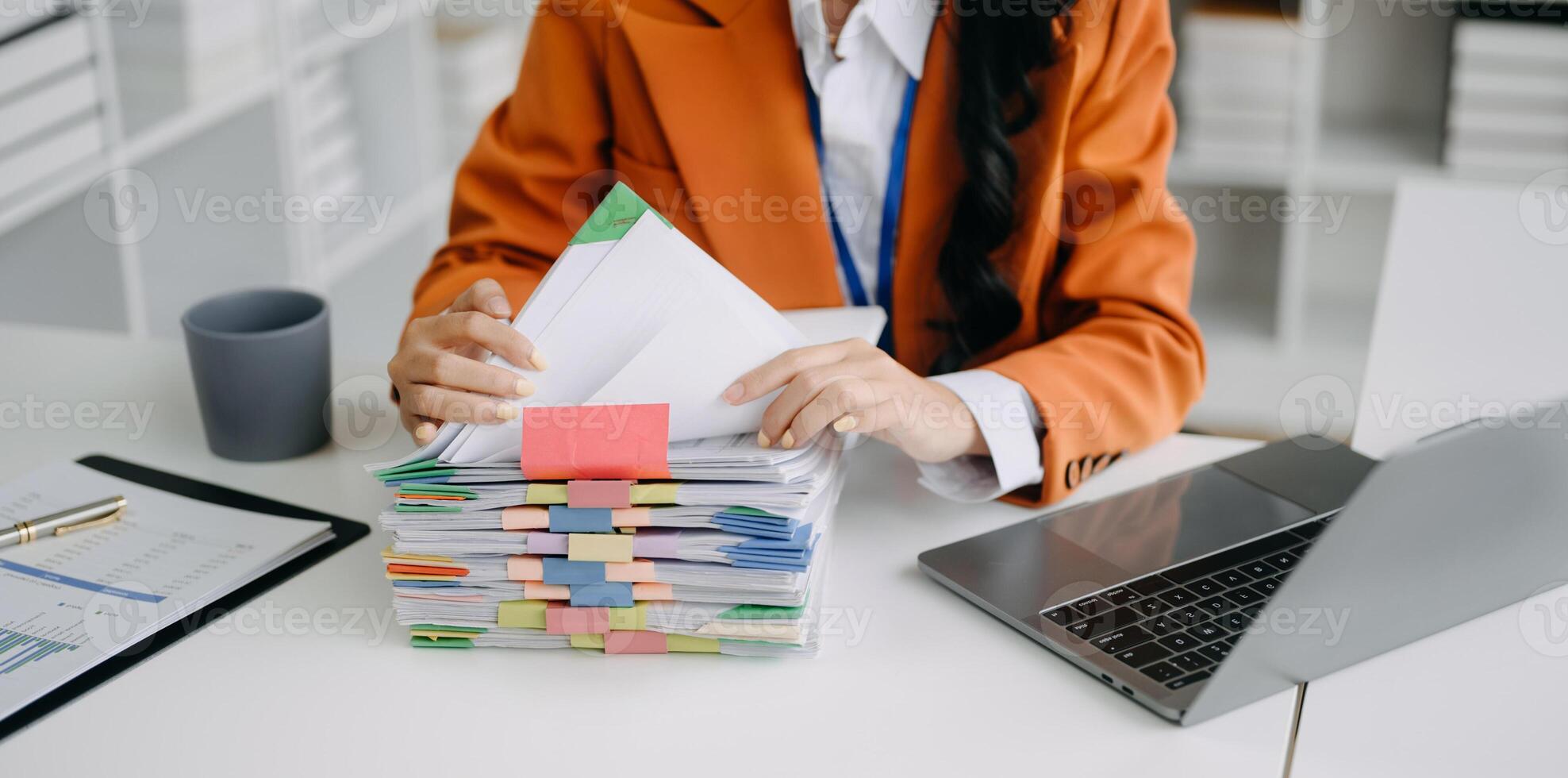 business documents on office table with smart phone and digital tablet and graph financial and woman working at modern office photo