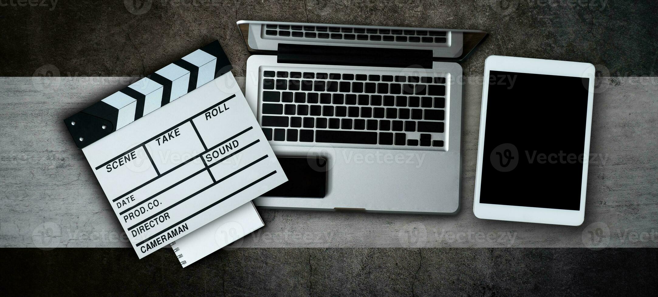 office stuff with Movie clapper, laptop, smartphone, tablet, coffee cup, pen, notepad and documents on the modern table top view shot. photo