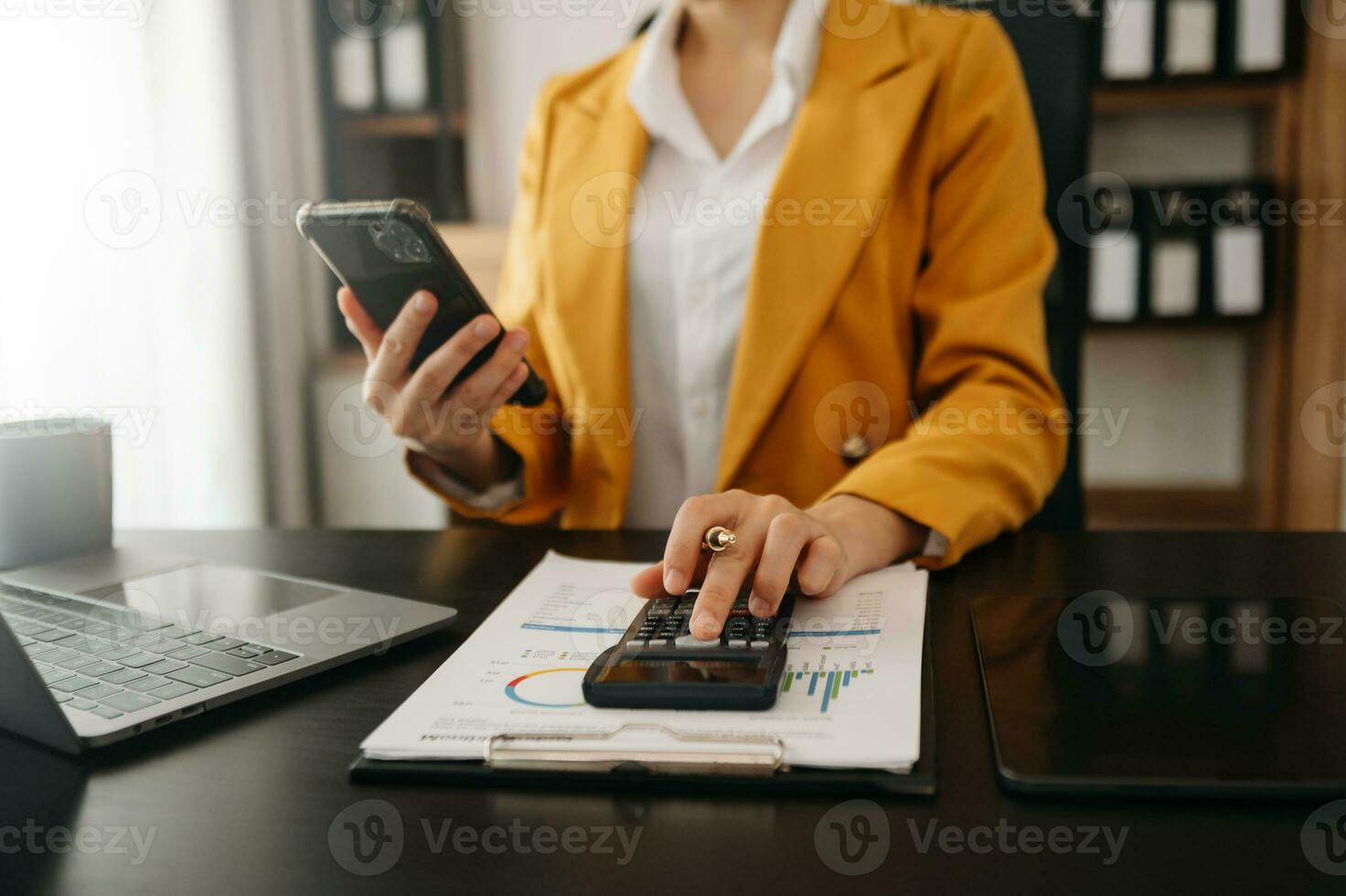 mujer contando monedas en calculadora tomando desde el cerdito banco. mano participación bolígrafo trabajando en calculadora a calcular en escritorio acerca de costo a oficina. foto