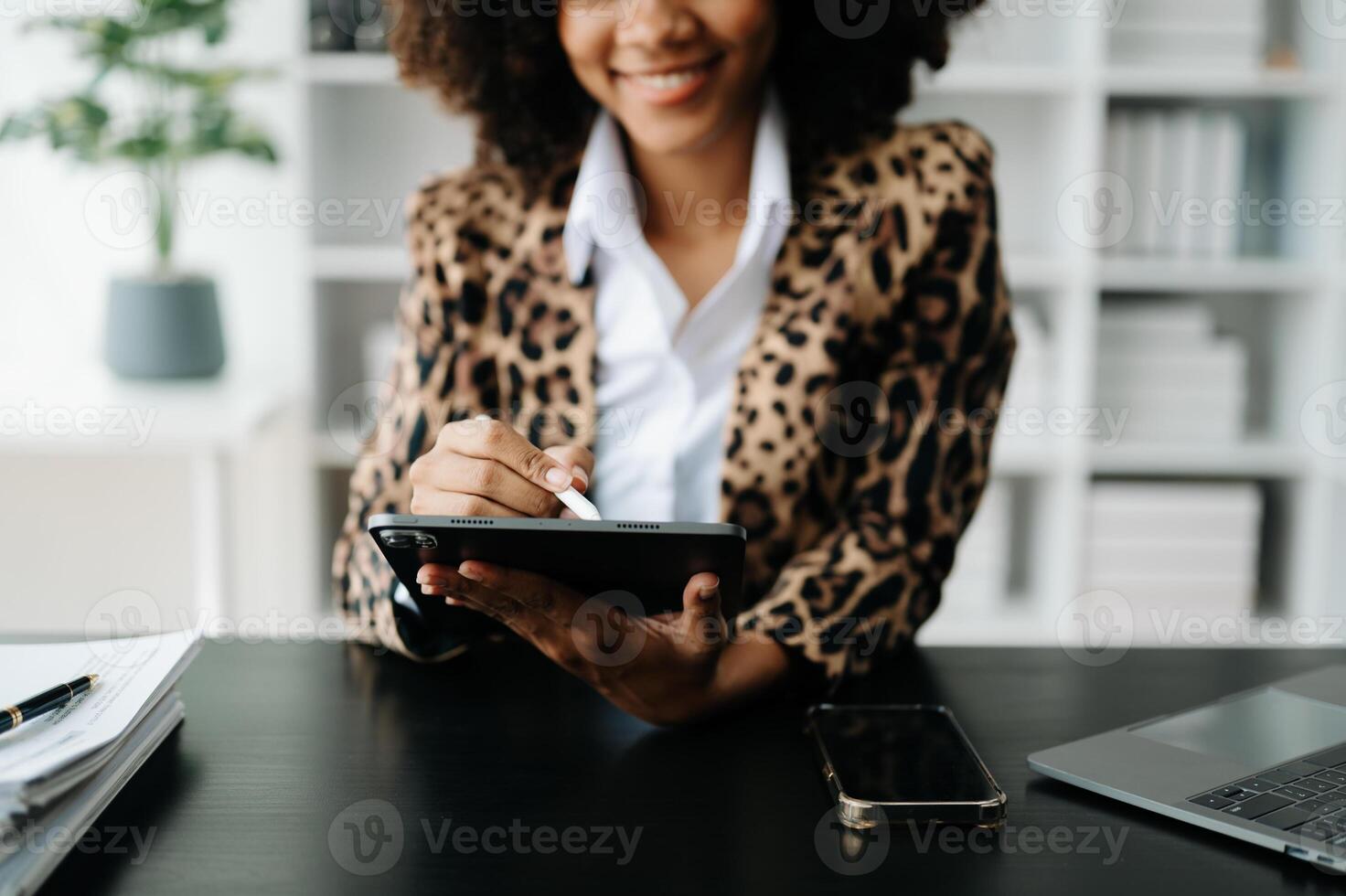 African Woman using smart phone for mobile payments online shopping,omni channel,sitting on table,virtual icons graphics interface screen photo