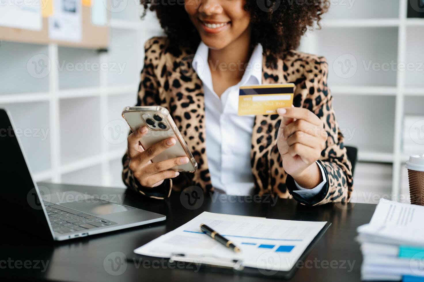 African Woman using smart phone for mobile payments online shopping,omni channel,sitting on table,virtual icons graphics interface screen photo